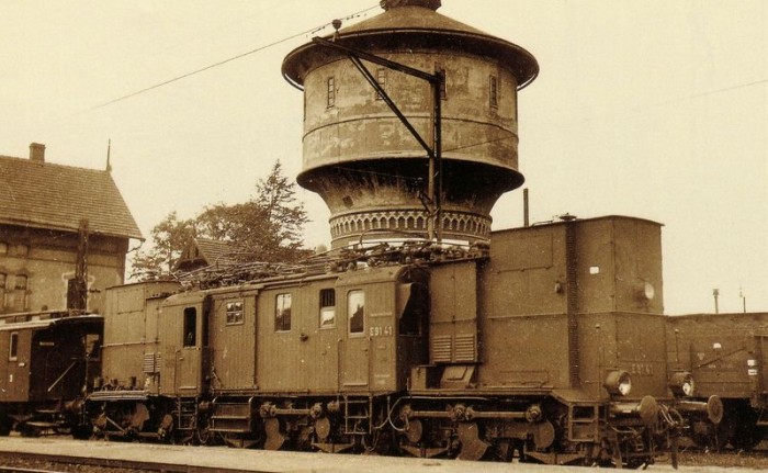 Elektrowóz ŚKG "odpoczywa" na stacji w Lubaniu ( w tle istniejąca do dzisiaj wieża ciśnień)